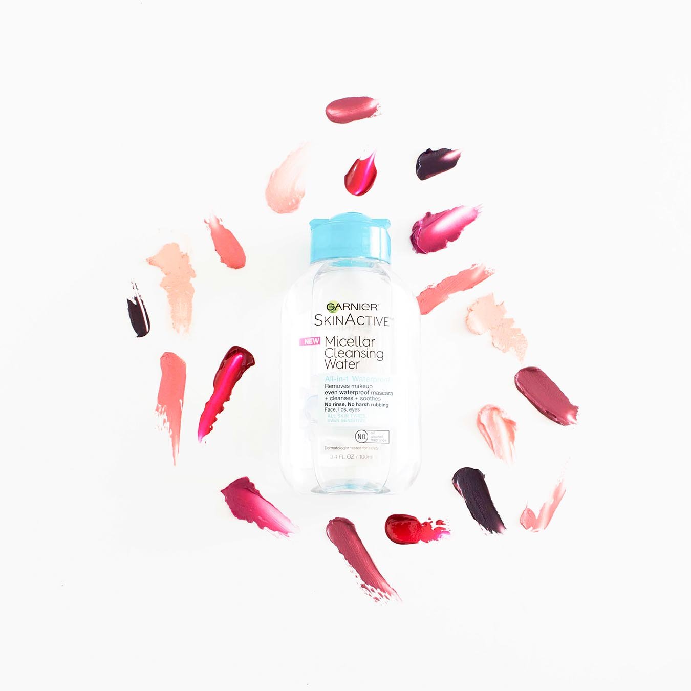 Garnier SkinActive Micellar Cleansing Water All-in-1 Waterproof 3.4 oz with blue lid on white background with various smudges of red and pink lipstick.